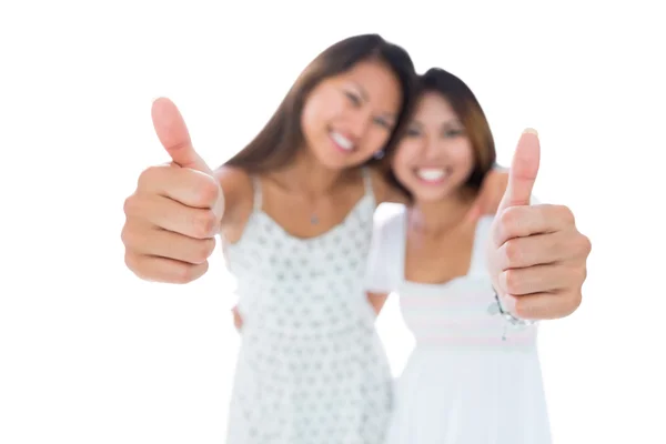 Twee mooie jonge vrouwen tonen duimen omhoog — Stockfoto