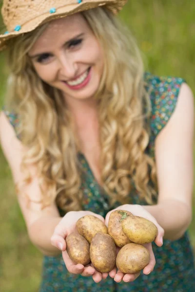 Blonde jonge vrouw overhandigen wat aardappels — Stockfoto