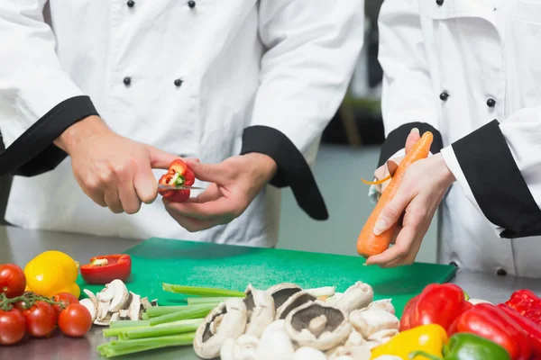 Närbild på två kockar förbereda grönsaker — Stockfoto