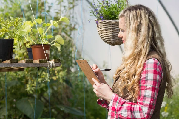 Blondine mit Klemmbrett und Notizen — Stockfoto