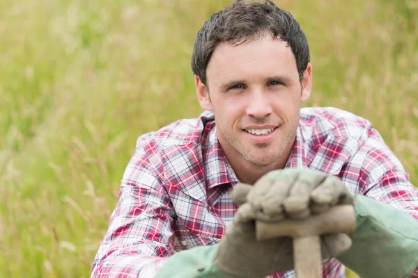 Handsome young man leaning on his shovel — Stock Photo, Image