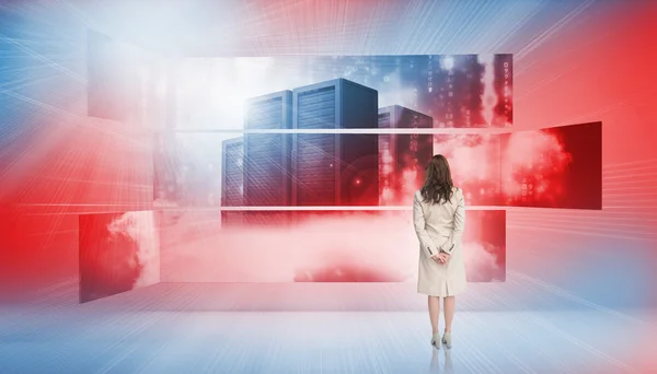 Vista trasera de la mujer de negocios mirando las pantallas que muestran torres de servidores —  Fotos de Stock