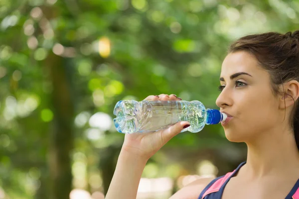 Sportiga kvinnan dricksvatten utomhus — Stockfoto