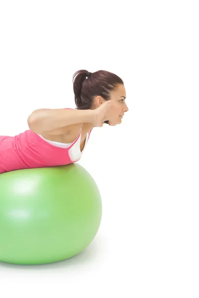 Conteúdo morena esportiva fazendo exercício na bola de exercício — Fotografia de Stock