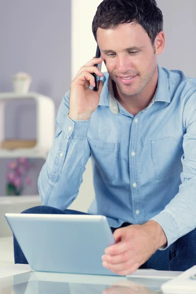 Happy casual man using tablet and phoning — Stock Photo, Image