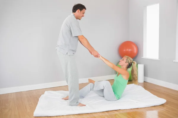 El fisioterapeuta contenido ayuda al paciente a hacer ejercicio — Foto de Stock