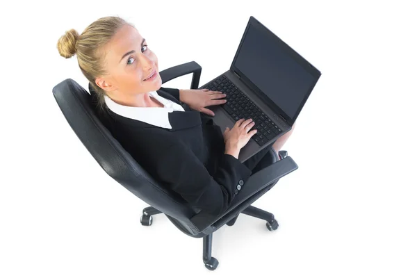 Junge Geschäftsfrau arbeitet mit ihrem Notizbuch auf einem Bürostuhl sitzend — Stockfoto