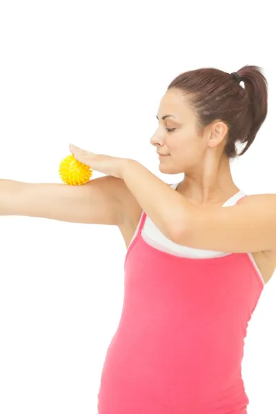 Содержание спортивная брюнетка касаясь руки с желтым мячом массажа — стоковое фото
