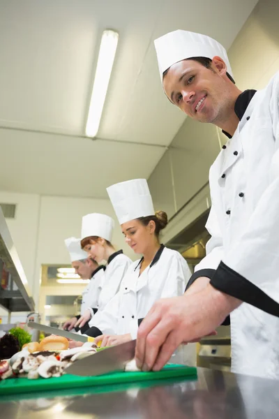 Joven chef masculino cortando verduras — Foto de Stock