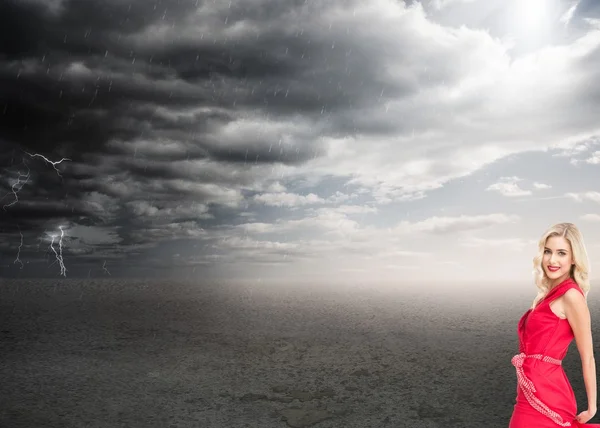 Pretty blonde in red dress posing and smiling — Stock Photo, Image