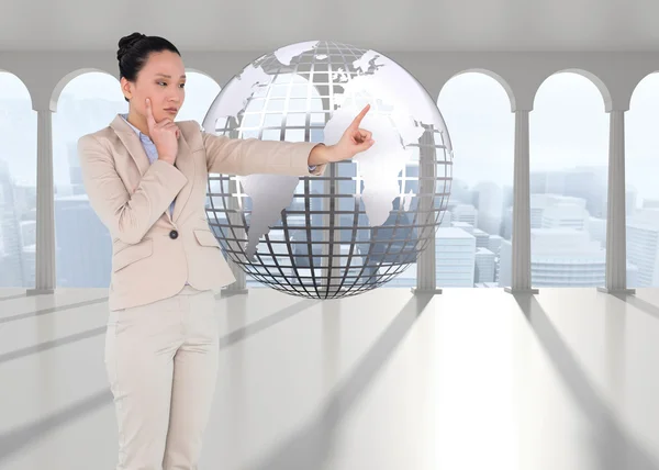 Composite image of thoughtful asian businesswoman pointing — Stock Photo, Image