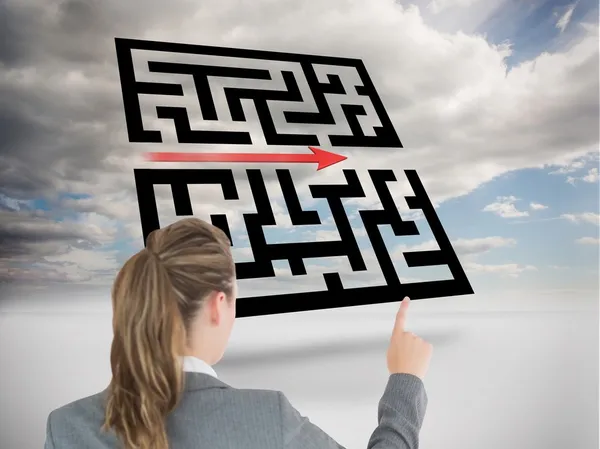 Businesswoman pointing at holographic maze — Stock Photo, Image