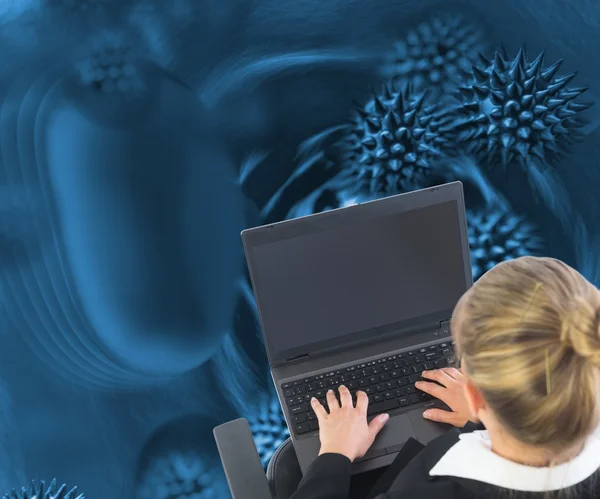 Blonde businesswoman sitting on swivel chair with laptop — Stock Photo, Image