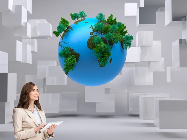 Businesswoman holding tablet and looking up — Stock Photo, Image