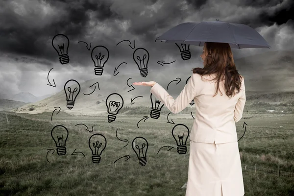 Composite image of elegant businesswoman holding black umbrella — Stock Photo, Image