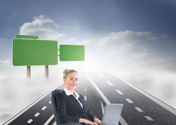 Businesswoman sitting in swivel chair with laptop — Stock Photo, Image