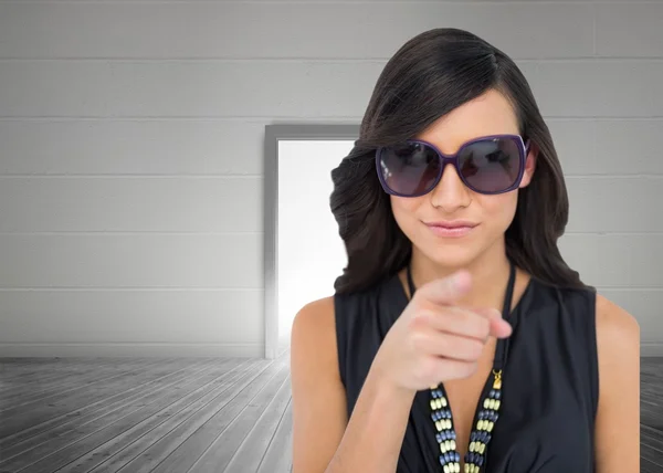 Elegant brunette wearing sunglasses pointing at camera — Stock Photo, Image