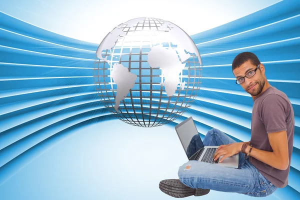 Man wearing glasses sitting on floor using laptop — Stock Photo, Image