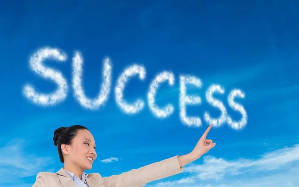 Composite image of smiling asian businesswoman pointing — Stock Photo, Image