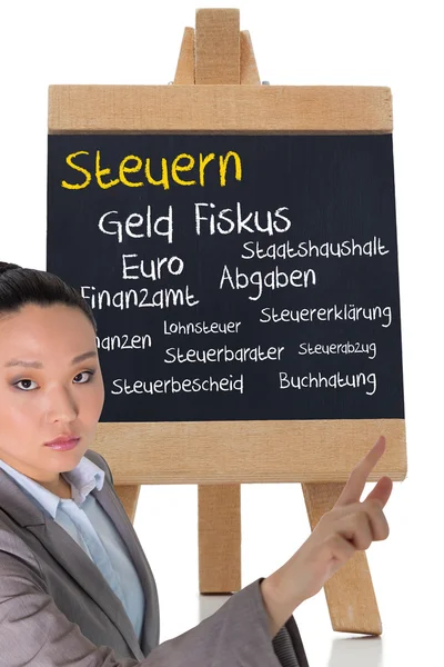 Composite image of unsmiling asian businesswoman pointing — Stock Photo, Image