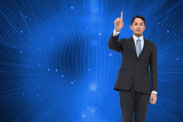 Composite image of serious asian businessman pointing — Stock Photo, Image