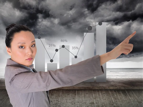 Composite image of unsmiling asian businesswoman pointing — Stock Photo, Image