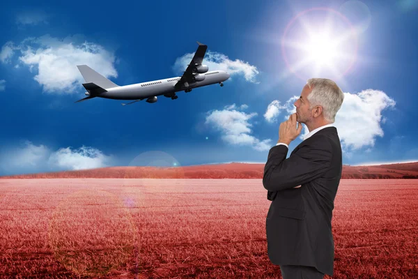 Composite image of thoughtful mature businessman posing — Stock Photo, Image