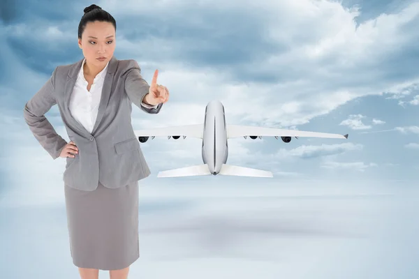 Composite image of unsmiling asian businesswoman pointing — Stock Photo, Image