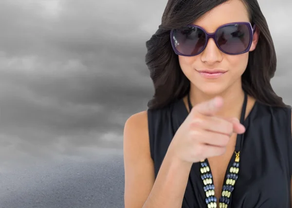 Elegant brunette wearing sunglasses pointing at camera — Stock Photo, Image