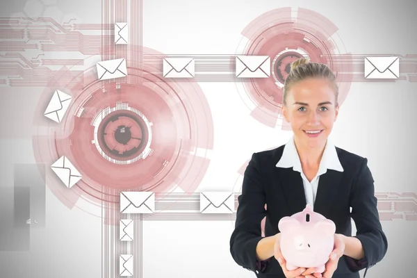 Blonde businesswoman holding pink piggy bank — Stock Photo, Image