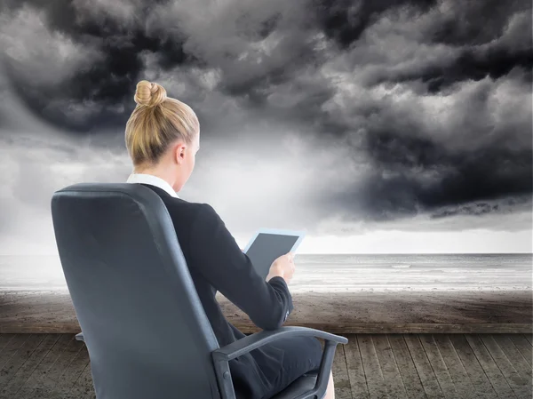 Composite image of businesswoman sitting on swivel chair with ta — Stock Photo, Image