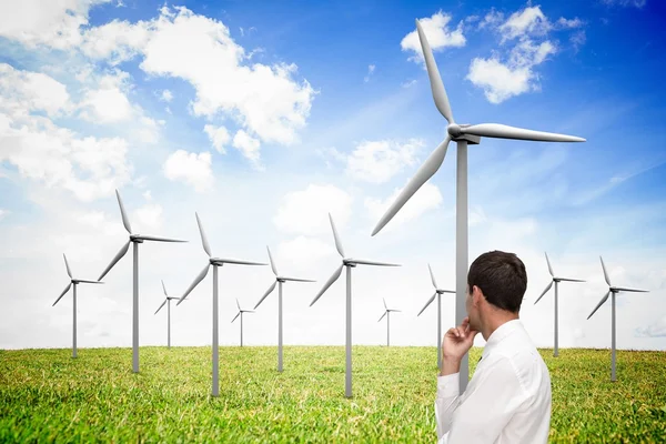 Empresário elegante pensativo olhando para moinho de vento — Fotografia de Stock