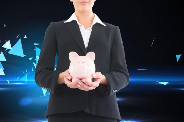 Composite image of businesswoman holding piggy bank — Stock Photo, Image