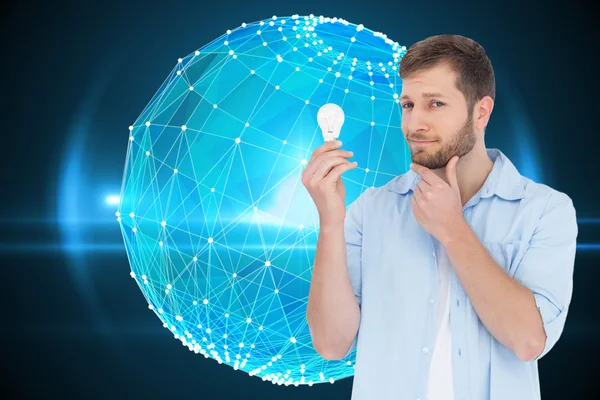 Composite image of handsome model holding a bulb — Stock Photo, Image