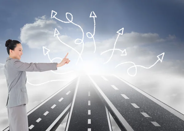 Composite image of smiling asian businesswoman pointing — Stock Photo, Image