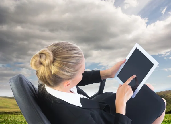 Affärskvinna som sitter på snurrfåtölj med tablett — Stockfoto