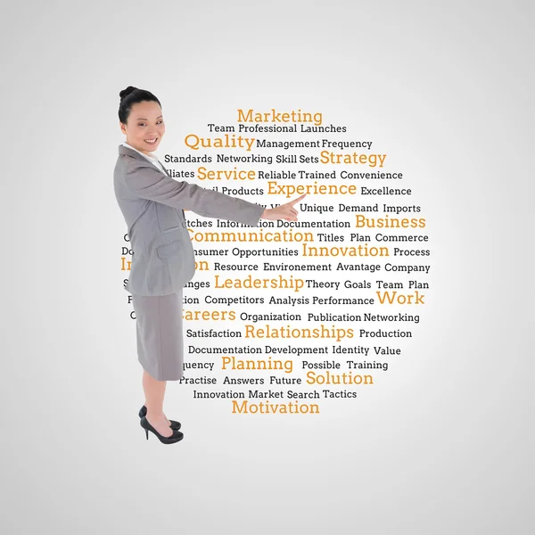 Composite image of smiling asian businesswoman pointing — Stock Photo, Image