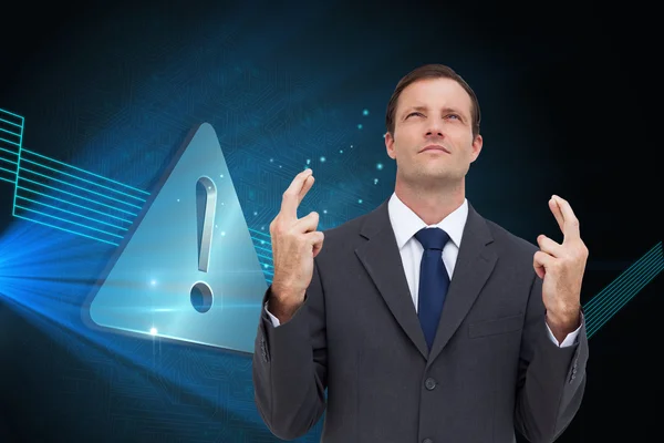 Serious businessman with fingers crossed is looking up — Stock Photo, Image