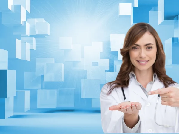 Smiling doctor pointing at something in her hand — Stockfoto