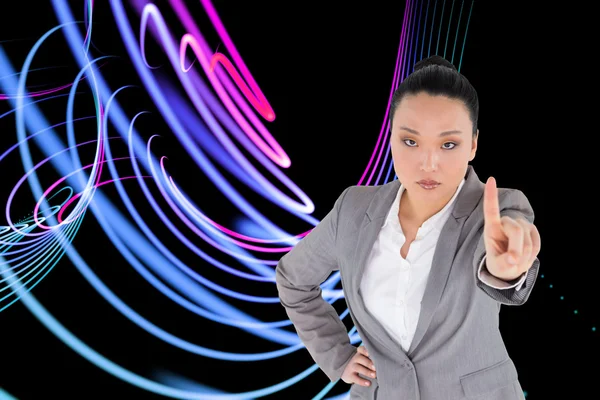 Composite image of unsmiling asian businesswoman pointing — Stock Photo, Image