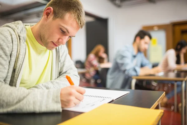 Studenti psát poznámky v učebně — Stock fotografie