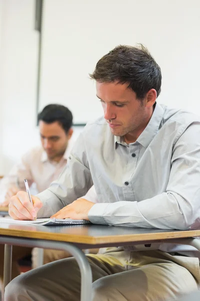 Estudiantes maduros tomando notas en el aula — Foto de Stock