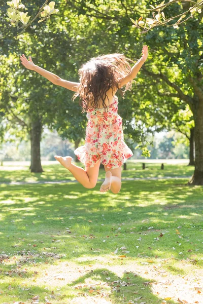 Rear view of attractive stylish brunette jumping in the air — Stock Photo, Image