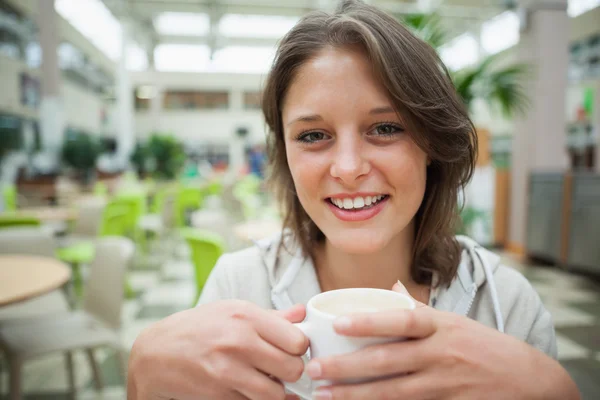 Χαμογελώντας φοιτήτριας πίνοντας καφέ στην καφετέρια — Φωτογραφία Αρχείου