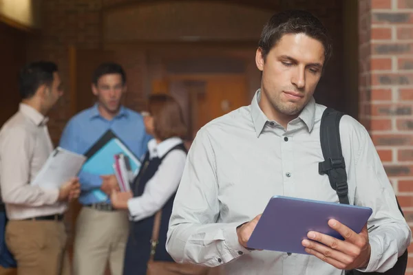 Сосредоточенный взрослый студент держит планшет стоя — стоковое фото