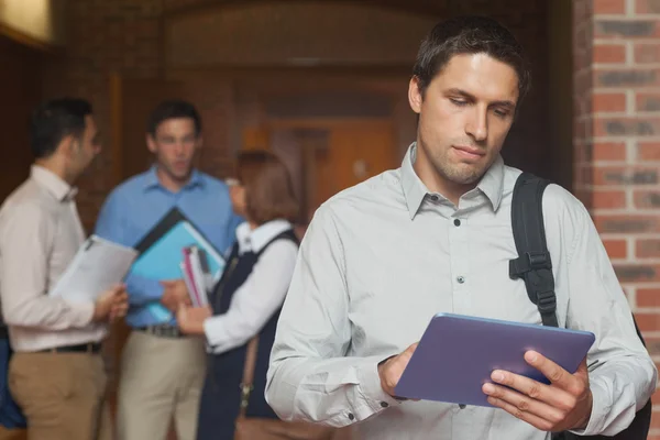 Concentrato maschio studente maturo tenendo il suo tablet in piedi in — Foto Stock