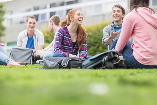 Vysokoškoláci sedí v parku — Stock fotografie