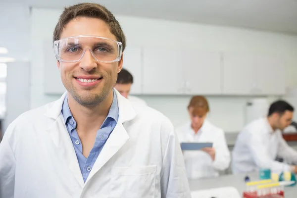 Usmívající se vědec s kolegy v práci v laboratoři — Stock fotografie