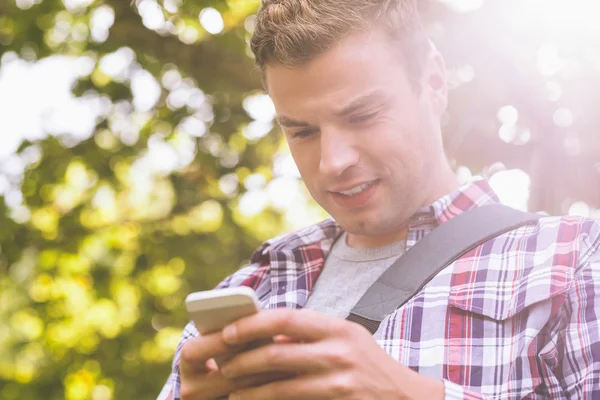 Beau étudiant debout et textos — Photo