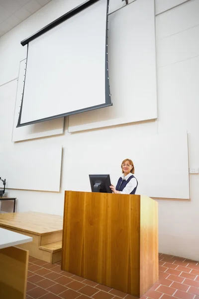 Profesor con ordenador y pantalla de proyección en sala de conferencias —  Fotos de Stock